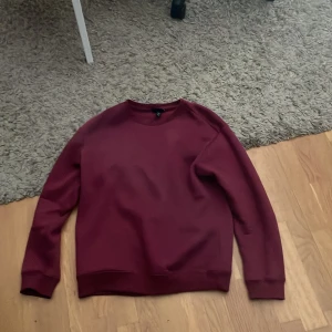 Vinröd sweatshirt från H&M - Säljer en vinröd sweatshirt från H&M i relaxed fit. Tröjan har rund halsringning och långa ärmar med ribbade muddar. Perfekt för en avslappnad stil och passar till många olika outfits.