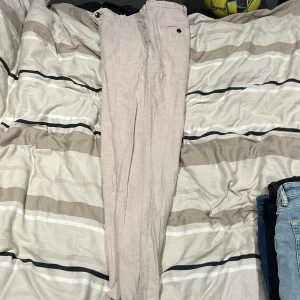 Ljusbeige linnebyxor från Produkt - Säljer ett par ljusbeige linnebyxor från Produkt. Byxorna har normal passform, knapp och dragkedja framtill samt fickor både fram och bak. Perfekta för varmare dagar tack vare det tunna linnematerialet.