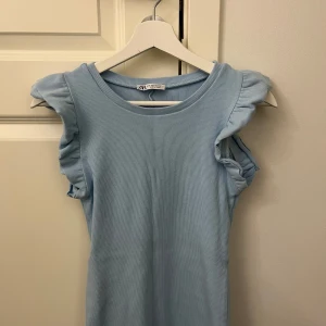 Klänning  - Supersöt ljusblå klänning från Zara i ribbat material. Klänningen har volangdetaljer vid ärmarna. Passar en S. Perfekt till sommaren💓💓