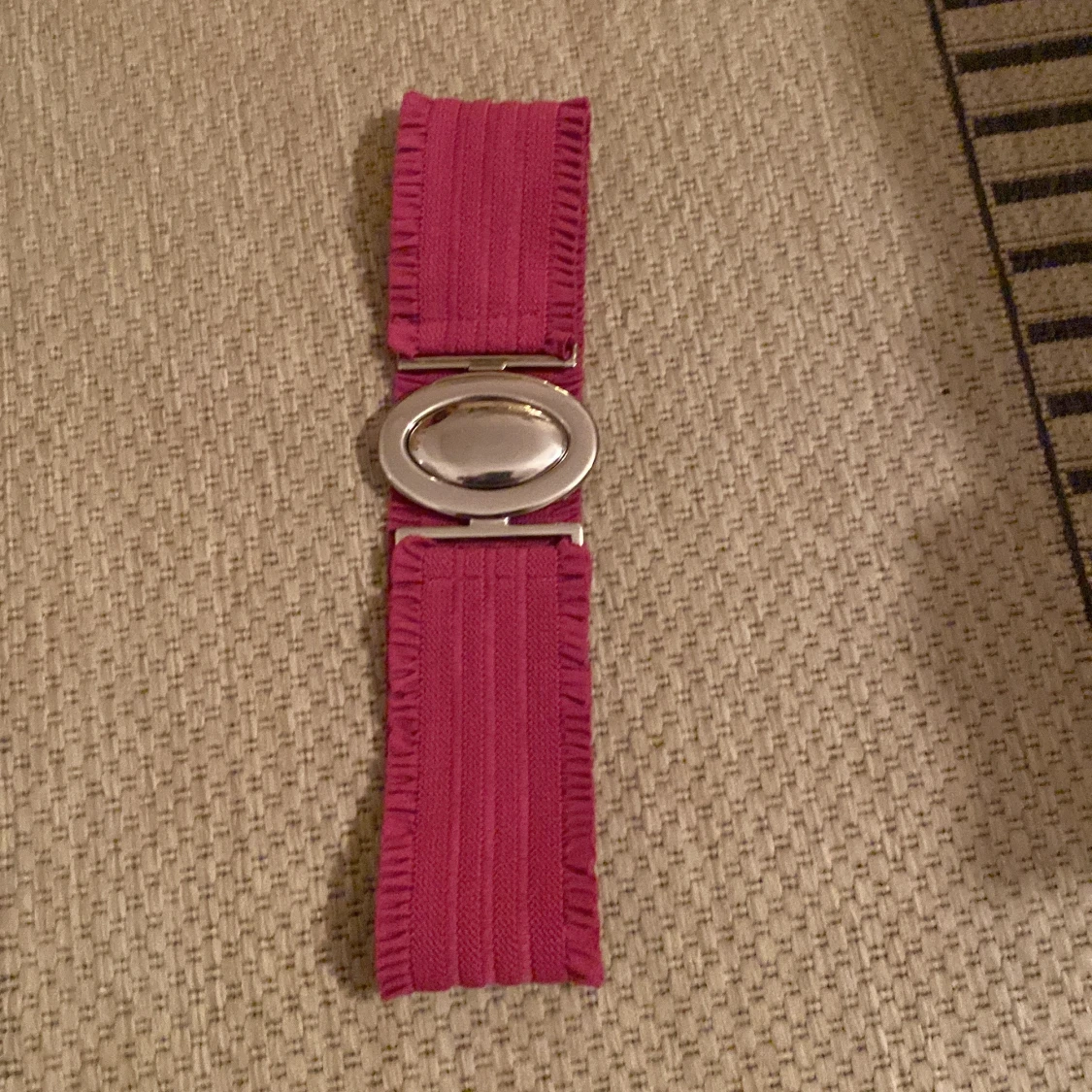 Rosa bälte med silverfärgat spänne