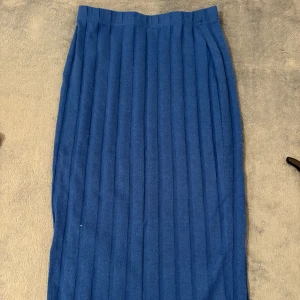 Blå ribbad långkjol - Säljer en blå långkjol med ribbad struktur. Kjolen har en rak passform och är enkel att matcha med olika toppar. 