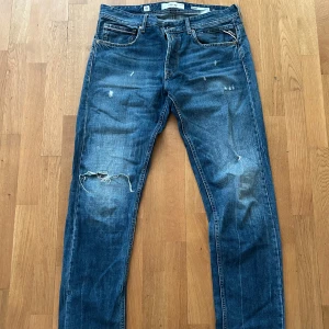 Blå Replay jeans med slitningar - Säljer ett par blåa jeans från Replay. Skick: 9/10, knappt använda. Väldigt snygg design. Vid frågor skriv till mig. Pris kan diskuteras.
