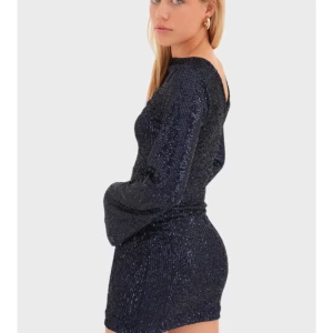 Mörkblå paljettklänning från Meet x Tiger - Säljer en glittrig mörkblå paljettklänning från Meet x Tiger i storlek XXS/XS. Klänningen har lång ärm, tight passform och är kort i modellen. Perfekt för dig som vill sticka ut med en snygg och trendig look.