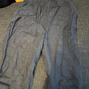 svarta linnebyxor - Säljer ett par grå linnebyxor med avslappnad passform och resår i midjan. Byxorna har sidfickor.