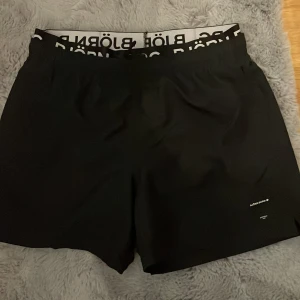 Svarta swim shorts från Björn Borg - Snygga svarta swim shorts från Björn Borg med elastisk midja och tydlig logotyp på linningen. Perfekta för stranden eller poolen, tillverkade i snabbtorkande material. Klassisk passform och stilren design. Sprillans nya, aldrig använda. Fick i present men var för små. Pris kan diskuteras 