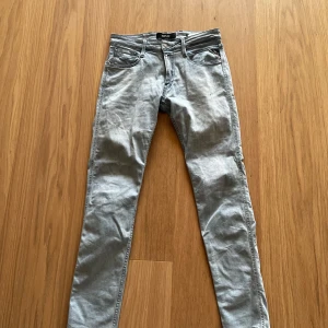 Ljusblå Replay Anbass jeans - Säljer ett par ljusblå Replay Anbass jeans med klassisk femficksdesign och snygga detaljer på bakfickorna. Jeansen har en slim passform och är perfekta för dig som gillar en stilren look. Märkeslapp bak i midjan och diskret Replay-logga på fickan. Nya 1350kr nu ändast 299kr!!!