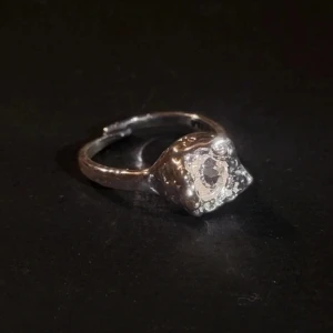 Silver plated ring från Pilgrim med unik form - Oanvänd adjustableCool ring silverplated (Rostar inte) från Pilgrim med en organisk, nästan smält design och en glittrande sten i mitten. Ringen har en robust känsla och sticker verkligen ut på fingret. Perfekt för dig som gillar unika accessoarer.