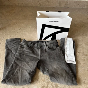 Grå jeansbyxor från Replay - Säljer ett par grå jeansbyxor från Replay med klassisk femficksdesign och svarta detaljer. Byxorna har normal passform och raka ben. Perfekta för dig som gillar stilrena och tidlösa jeans. Helt nya och fräscha. Passar dig som är 150-156, köpta från NK för 999kr säljer för endast 799kr