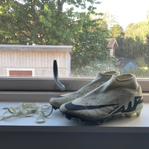 Nike fotbollsskor i vitt och svart - Säljer ett par gulvite och svarta Nike fotbollsskor med snörning och rund tå. Skorna har en platt sula med dobbar för bra grepp på planen. Perfekta för dig som vill ha stilrena och lätta skor till match eller träning. De är storlek 45 men passar strlk 43-44. Säljer för jag inte spelar fotboll längre. Mvh FLHN_SHOP