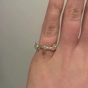 Unik silverring med organiska former - Säljer en cool och annorlunda ring i silver med organiska, böljande former och små klotdetaljer runt om. Perfekt för dig som gillar unika smycken med modern känsla. Ringen är justerbar så passar alla och man kan variera vilka fingrar man har den på