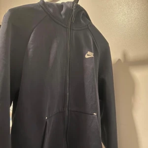 Nike Tech - Säljer Nike Tech från Nike med vit logga på höften. Byxorna har normal passform, resår i midjan och är tillverkade i mjukt bomullsmaterial. Perfekta för chill eller träning.