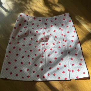 Kjol m jordgubbar - Superfin rosa kjol från Monki med sött jordgubbsmönster och rutigt i bakgrunden.  Rak passform och är kort i modellen. Materialet andas och är perfekt för sommaren 💖