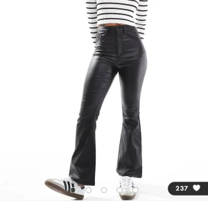 Svarta skinnbyxor med bootcut - Skit snygga svarta byxor i skinnimitation med bootcut och hög midja. Helt nya med prislapp på. Storlek m/28 och köpta på asos 