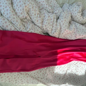 Maxiklänning från Gina - Rosa satinklänning från Gina, storlek M men passar XS/S. Lång till marken på mig som är 168 cm. En slits fram. Använd en gång på studentmottagning förra året, tyvärr lite slitage men inget märkbart.  