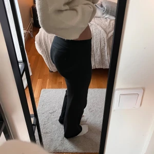 Svarta träningsbyxor från Nike - Svarta träningsbyxor från Nike med diskret logga på höften. Byxorna har medelhög midja och en tight passform upptill som blir rakare nertill. Perfekta för gymmet eller vardagslooken. Inga defekter 