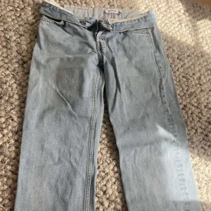 Ljusblå jeans från Weekday - Säljer ett par ljusblå jeans från Weekday med klassisk femficksdesign och raka ben. Jeansen har normal passform och stängs med dragkedja och knapp. Perfekta för en avslappnad stil. De är även lågmidjade