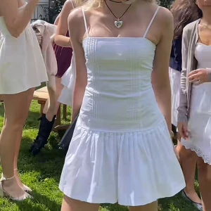 Vit kort klänning med smala axelband - Så fin klänning med plisserad underdel!! Perfekt till sommaren