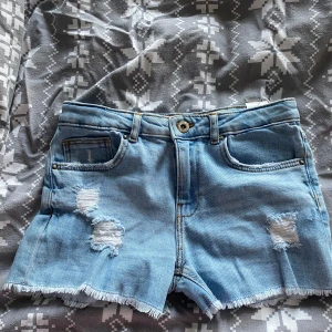 Ljusblå jeansshorts med fransar från ZARA - Säljer ett par ljusblå jeansshorts från ZARA. Ganska stora k storleken