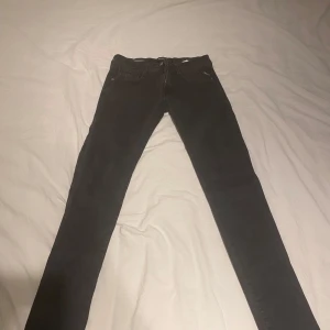 Svarta slim jeans från Replay Anbass - Säljer ett par svarta slim fit jeans från Replay, modell Anbass. Jeansen har klassisk femficksdesign, dragkedjegylf och smal passform. Perfekta för dig som gillar en stilren look med bekväm känsla. Buda gärna! FÖRST TILL KVARN!