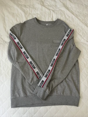 Moschino sweatshirt  - Helt ny moschino sweatshirt endast testad en gång och har bara hängt i gerderoben, Den är köpt på moschino hemsida för 1800kr säljer den för 1000kr men kan sänkas vid snabb affär  Storlek L