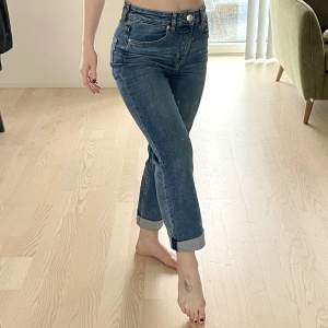 Blå jeans från H&M i stl 36 men passar även mig som brukar ha 34. Skönaste jeansen jag ägt men de kommer tyvärr inte längre till användning. Material: 93% bomull, 6% polyester, 1% elastan. Benen är i avklippt stil. För referens på längd så är jag 162 cm. 