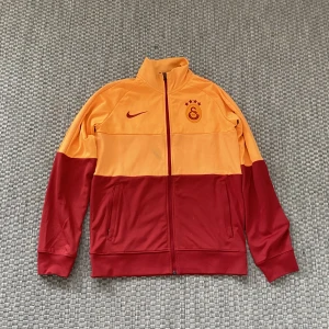 Galatasaray zip-tröja - Galatasaray långtröja med märket nike, tröjan har en mindre fläck på framsidan, skicket är väldigt bra utöver fläcken 