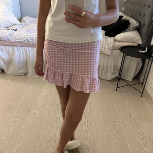 Kjol  - Säljer denna fina kjol från Gina tricot då den är lite liten för mig. Kjolen har en väldigt fin resor detalj på ena sida. Kjolen är sparsamt använd och i väldigt bra skick!