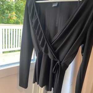 Volang knytblus - Jättesöt blus som man knyter i midjan. Volang detalj längs ena sidan samt lite volanger på undre hälften. Inga defekter