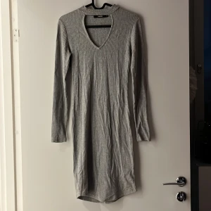 Klänning XS - Knälång klänning i ribbat material med urringning och liten krage. Långärmad Ljusgrå  Bikbok  Storlek: 34/XS  Sparsamt använd! 