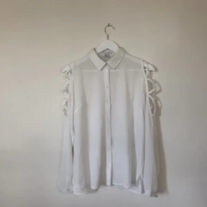 Vit skjorta - Jättecool vit skjorta med detaljer på ärmarna från NewYorker. Storlek S. Nyskick. 