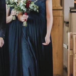 Långklänning  - Fin maxiklänning använd en gån som brudtärna. Marinblå. Spets upptill. Insydd tubtopp fram. Meshtyg i lager i kjoldelen. Jättesnyggt fall! 