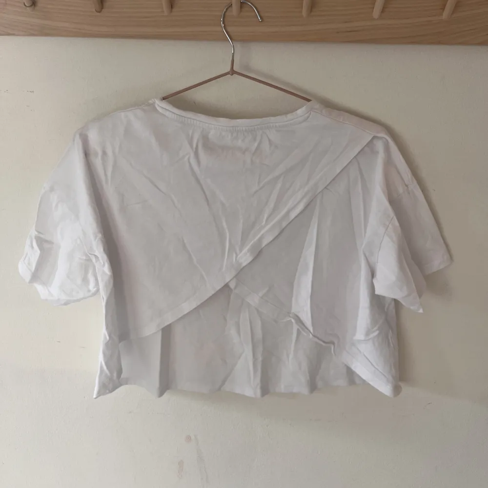 Croppad T-shirt med krosad öppen rygg från Mango. Den är i strl M och är använd ett fåtal gånger.  Skriv för mer bilder!😊. T-shirts.