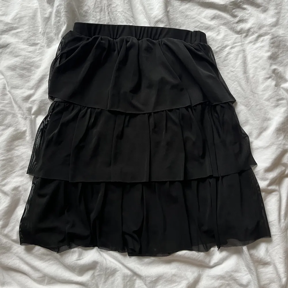 En volang kjol i svart från nelly. Stretchig och resår i midjan. Säljs gärna snabbt därför lågt pris!! O inga bilder med den på då jag inte har det🌟. Kjolar.