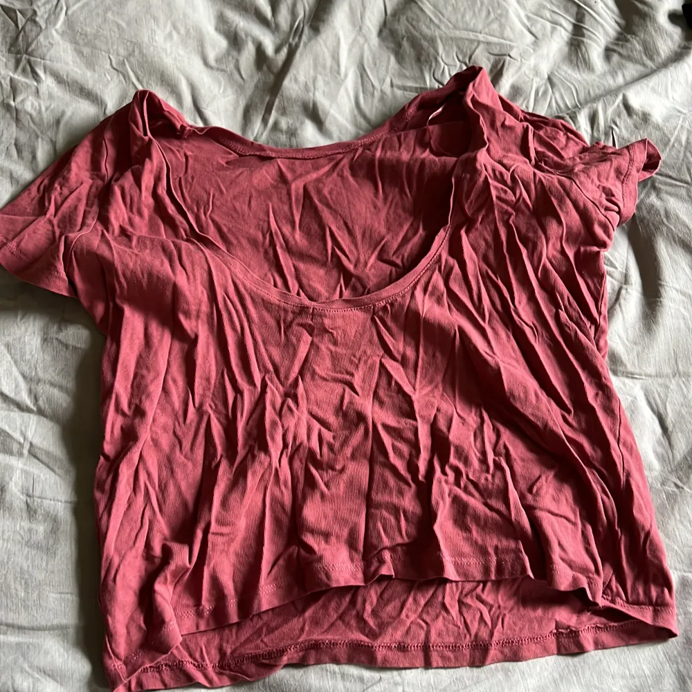 Gammalrosa T-shirt som är låg i ryggen. Fint skick. Som man ser behöver den strykas 😅. Toppar.