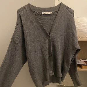 Stickad kofta - Perfekta gråa färgen, och är i jättebra skick! Skriv om du skulle undra något!
