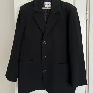 Svart kavaj  - En oversized kavaj med axelvaddar från Nakd. Oanvänd så väldigt fint skick! 