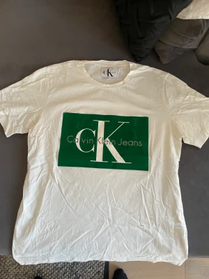 CK T-shirt  - Calvinklein T-shirt med grönt  mocka tryck på bröstet.