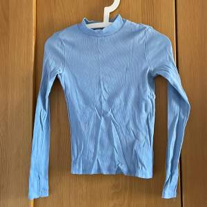 Långärmad ljusblå tight tröja med halv polokrage från monki 