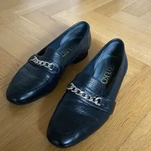 Svarta, trendiga loafers i mjukt skinn med dekorativt silverspänne. Skorna är supersköna och är det nyskick.   Ordpris 900:-