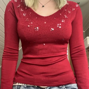 röd tröja - en röd v-neck tröja med massor av paljetter och pärlor längst kragen🥰står storlek L men uppskattar den som en storlek S-M. inte direkt nopprig men vissa trådar kan sticka ut ibland, brukar bara klippa av dem då men brukar inte hända jätte ofta💗
