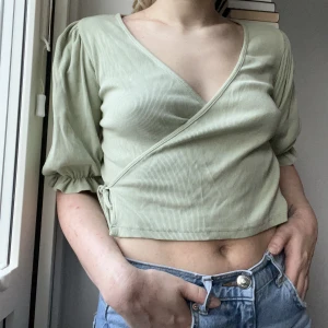 Grön topp - Grön omlott-topp från Monki!💚Croppad modell, passar perfekt till våren! Använd men i mycket fint skick.