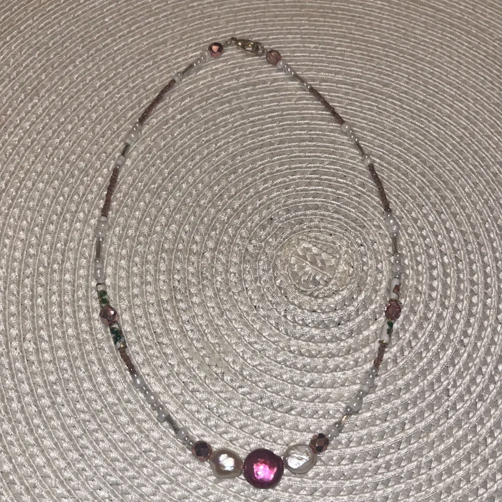 Ett pärl halsband som är lila och vit. Accessoarer.