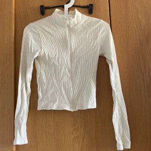 Kofta - Supersnygg tajt beige zip kofta från Gina tricot. 