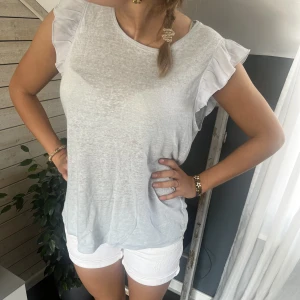 Tröja + shorts  - Vi säljer hela denna outfiten! (Vita jeans shorts + en jätte fin babyblå volang tröja. Shortsen är i S/M och tröjan är i S. 