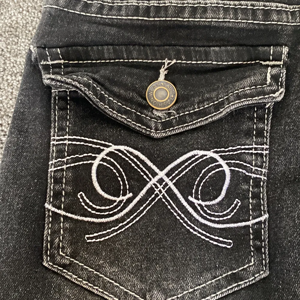 Svarta jeans som är Lågmidjade. Fickor med knappar och mönster. Storlek xs. Använd 3-4 gånger (nyskick). Jeans & Byxor.