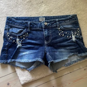 Lågmidjade jeansshorts - Superunika coola jeansshorts med stenar!!! Så fin och najs blå färg, Sorlek W27 !!!Har inte bild på!!! tar inte fler bilder!!!