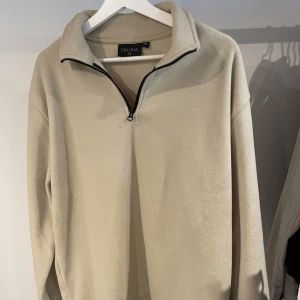 Fleece  - Beige fleece med halv zip. Nästan aldrig använd, mkt bra skick. 