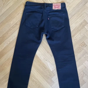 Levis 501 - Ett par riktigt fina svarta Levis 501. Byxorna i fint skick men slitage längst ner finns (se bild). Storlek 30/30  Måtten är: W 38,5cm (mätt rakt över) L 100cm (Mätt från midja till benslut)