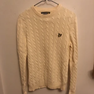 Kabelstickad tröja från Lyle & Scott, Storlek XS - Storlek XS men passar nog även de flesta med S. Ivory kallar Lyle & Scott själva färgen så det är vitt med gula inslag. Gammal men längesen jag använde den. Nypris 1100kr
