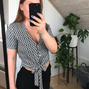 Croptop med knytband - Topp från Vero Moda i storlek XS (passar S). Fint mönster i svart & vitt med knappar och knytband framtill. Tyvärr för liten för mig så den är helt oanvänd!🌸Gjord av 100% viskos.